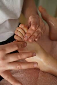 Photo de Joanna Thomann, fondatrice de Douceur des Lunes, Doula, energéticienne à Annecy qui réalise une séance de réflexologie émotionnelle sur une enfant
